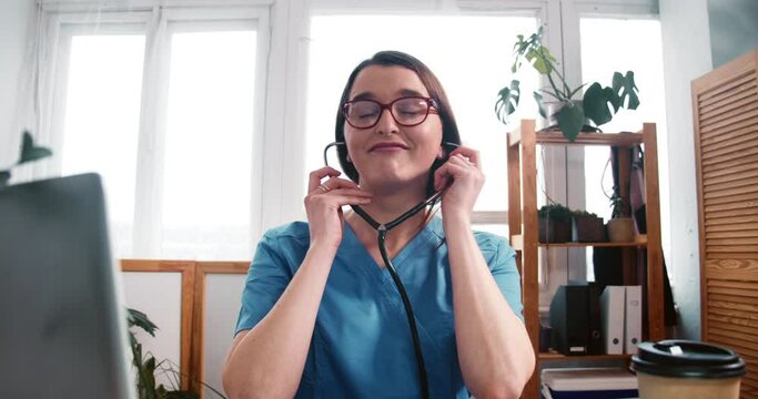 Zoom in on fun young happy Caucasian female lab scientist doctor dancing at table, celebrating victory over coronavirus.