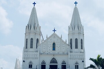 Basilica of Our Lady of Good Health, Sanctuary of St. Mary's shrine, Cathedral of St. Mary, facade of holy trinity. Roman Catholic Latin church tower against blue sky background in Velankanni.