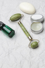  Natural organic skin care product. Home spa and self care concept. Facial serum, jade roller and soap bar with copy space.