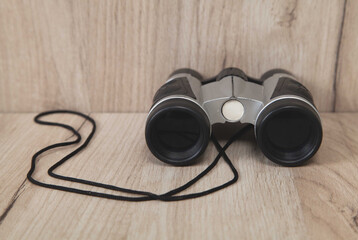 Binoculars on an isolated wooden background.