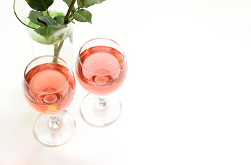 Two glasses of pink wine are on the table.