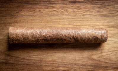 Brown cuban cigar on wooden background