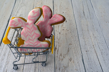 Easter bunny in a supermarket trolley. Shopping for Easter. Rabbit-shaped cookies. Bunny decorated...