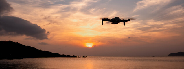 Horizontal banner Drone flying in the sky at sunset soaring the sea waters