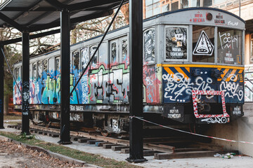Piece of metro train sitting in the outside of the university with graffiti