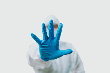 People wearing medical gloves and personal protective equipment, mask, goggle and suit to protect...