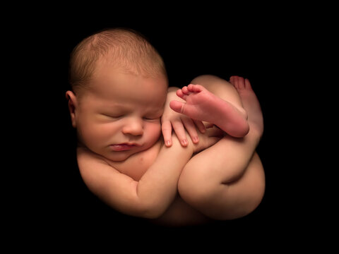 Newborn baby in foetus pose