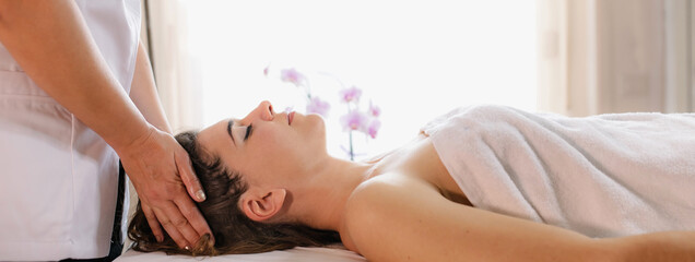 Obraz na płótnie Canvas Horizontal banner Spa head massage. Side view woman enjoying relaxing face massage in beauty spa salon