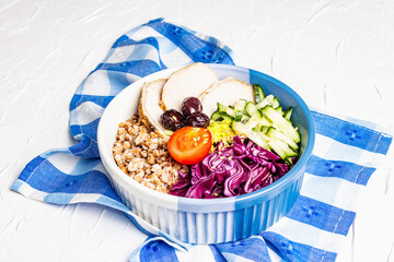 Buddha Bowl with buckwheat, baked lean pork, red cabbage, cucumber, tomato, olives, flax seeds