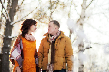 Fototapeta premium Warm winter portrait of young interracial smiling couple on a walk in the forest
