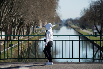 Portrait of teenager  wearing a black jeans pants and white Hoodie Sweatshirt walking in the street