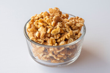Raw walnuts in a bowl on withe background