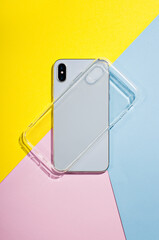 iPhone X clear case mockup, smart phone back view on the background of colored paper, blue, pink,...