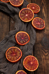 Slices of red oranges on a dark wooden background. Rustic style