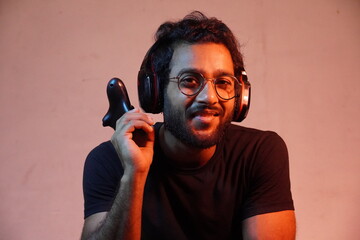 yong man with playing game's Joystick and wearing headphone