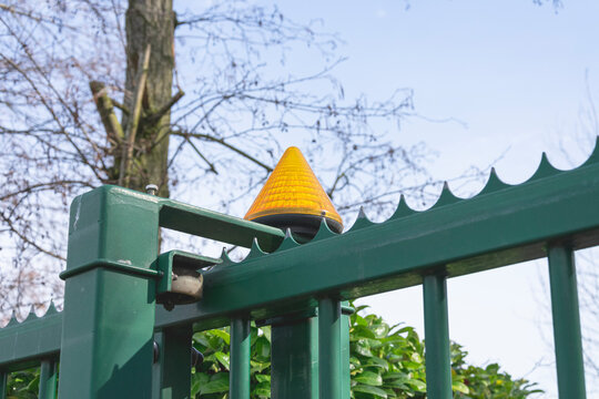 Orange lamp on an automatic green gate that activates when the gate opens