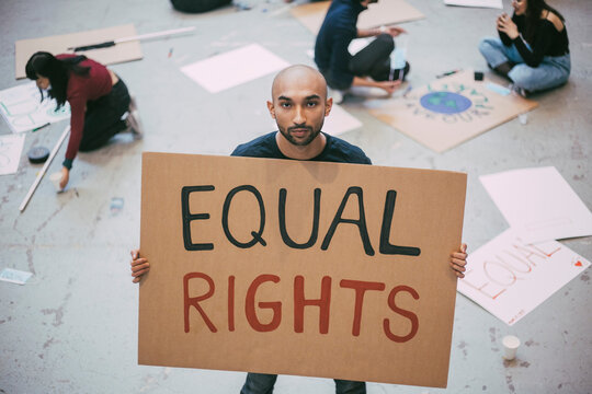 Bald man with equal rights sign standing in building