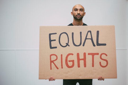 Male protestor with signboard against white wall