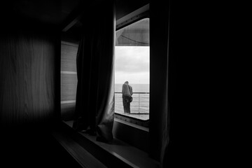 A ferry inside with one passenger in the morning, black and white