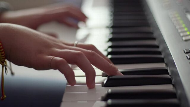 Woman hands playing piano with blur background
