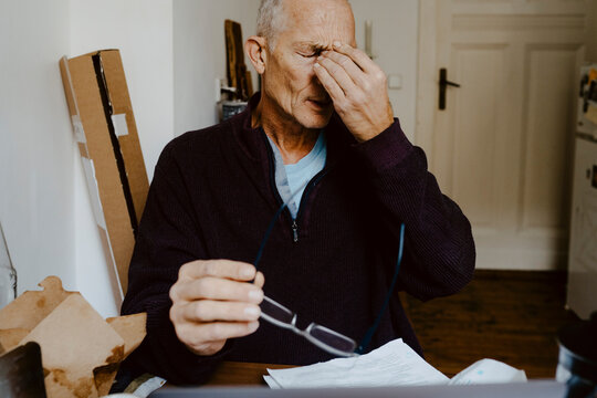 Worried male entrepreneur with eyes closed at home