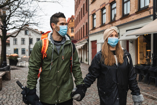 Female and male tourists exploring city during pandemic