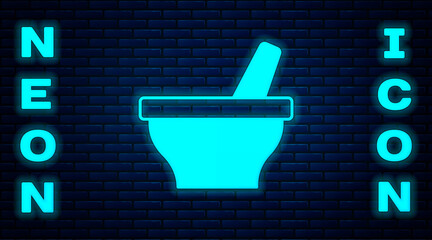 Glowing neon Mortar and pestle icon isolated on brick wall background. Vector