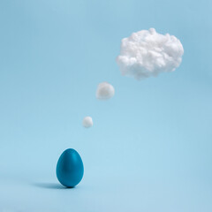 Blue Easter egg is thinking on pastel blue background. Comic book motive. Minimalistic concept.