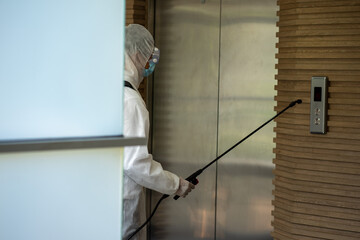 Asian healthcare medical workers wearing PPE protective suit disinfecting to building in new normal 