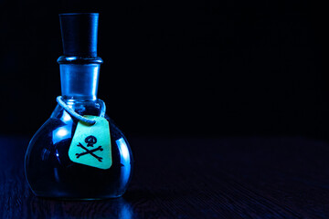 vial of poison with a hazard warning label, on a dark background, toning, short focus