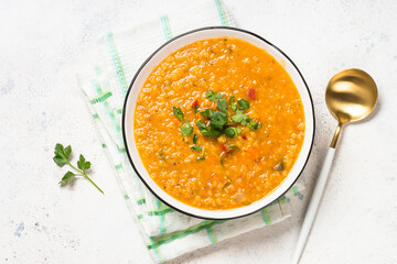 Lentil soup with vegetables at white stone table.