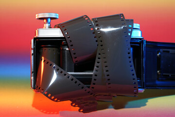 Analogue camera with Film on an colorful background photographed in the studio