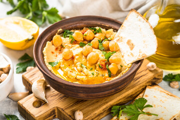 Hummus with olive oil and paprika at light kitchen table.