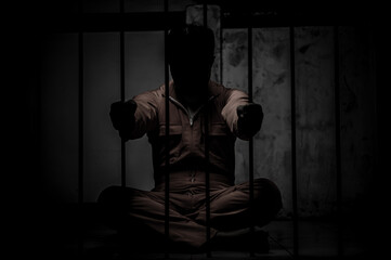 Asian man desperate at the iron prison,prisoner concept,thailand people,Hope to be free,Serious...