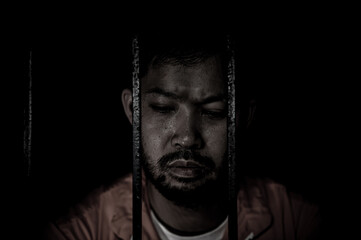 Asian man desperate at the iron prison,prisoner concept,thailand people,Hope to be free,Serious...