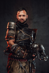 Naklejka premium Apocalyptic survivor posing with helmet in dark background
