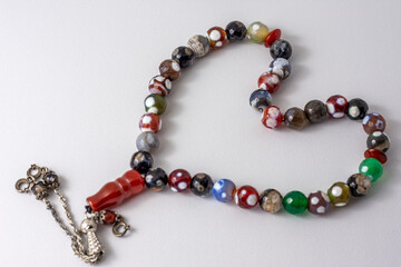 Colorful men's Muslim Prayer beads heart shape on white background 