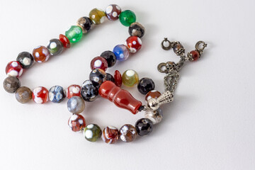 Close up colorful men's Muslim Prayer beads on white background, Ramadan concept 