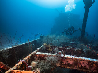 Diver at Ship wreck "Superior Producer" in turquoise water of coral reef in Caribbean Sea, Curacao