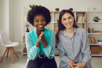 Portrait of millennial african american and caucasian partner laughing looking at camera having...
