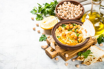 Hummus with olive oil and paprika at light kitchen table.