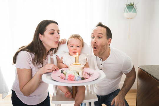 one year old little girl with daddy and mammy solemnize birthday