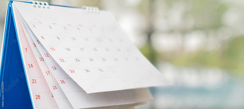 Wall mural close up white paper desk calendar with blurred bokeh background appointment and business meeting co