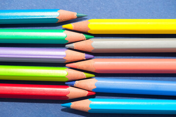 Arrangement of crayons on blue background, studio shot