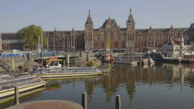 Boats on water, Amsterdam Centraal Station in background