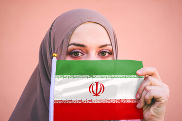 Muslim woman in hijab holds flag of Iran