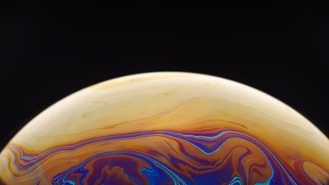 Close up of hidden beautiful and colourful of half soap bubble with abstract pattern on surface isolated with black background.
