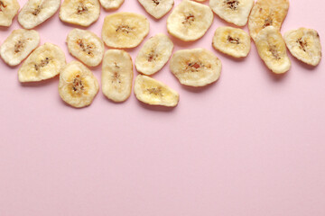 Composition with sweet dried banana slices on a pink background. Dried fruit as healthy snack