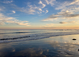 Fototapeta na wymiar sunset on the beach with sky reflection