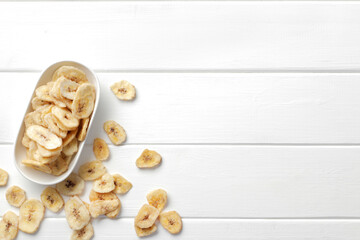 Flat lay composition with banana slices on white background, space for text. Dried fruit as healthy snack